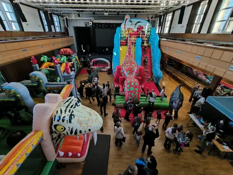 Hala plná dinosauřích skákacích hradů a atrakcí